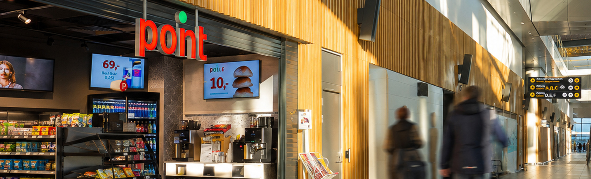 Kvinne som ser på magasiner ved en aviskiosk, med ulike fargerike magasinomslag og publiseringer