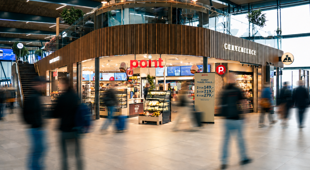Kvinne som blar i magasiner på et utsalg, med forskjellige fargerike magasinomslag og publikasjoner