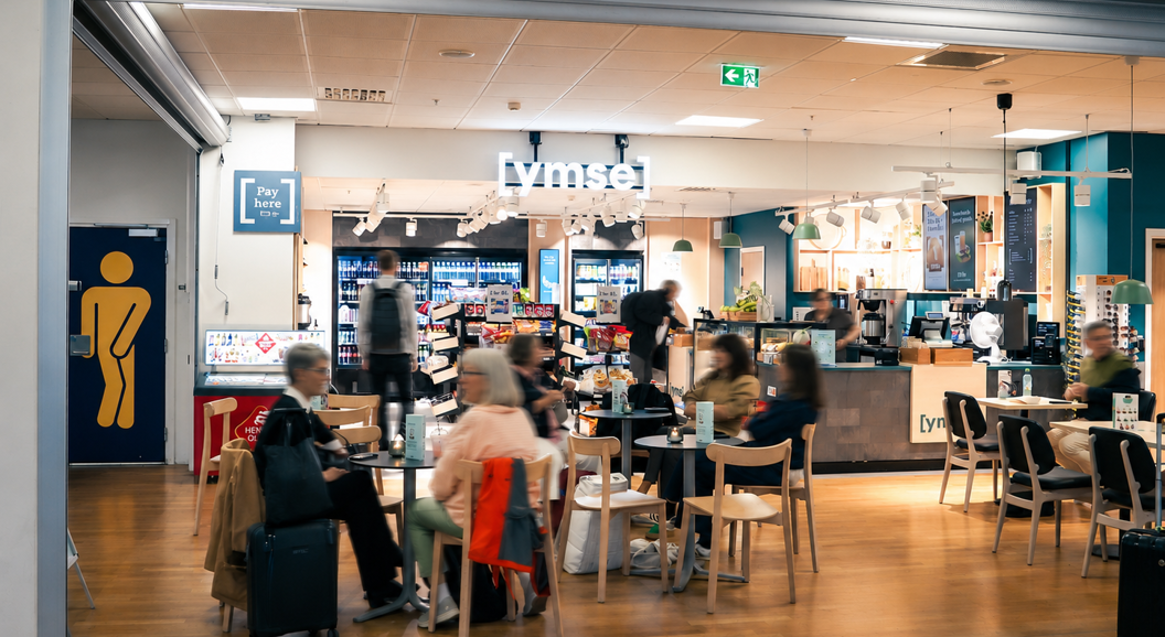 Assorterte smørbrød med salat, ost og kjøtt i en bakeridisk, med korn-toppede boller med synlige prislapper i norske kroner