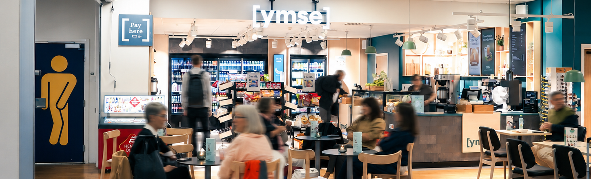 Assorterte smørbrød med salat, ost og kjøtt i en bakeridisk, med korn-toppede boller med synlige prislapper i norske kroner