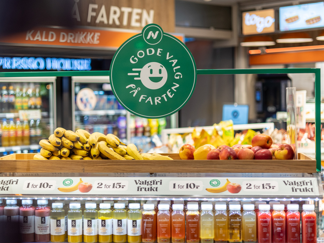 Moderne Narvesen-kiosk på en flyplass som tilbyr nødvendighetsartikler, snacks og drikkevarer under levende belysning