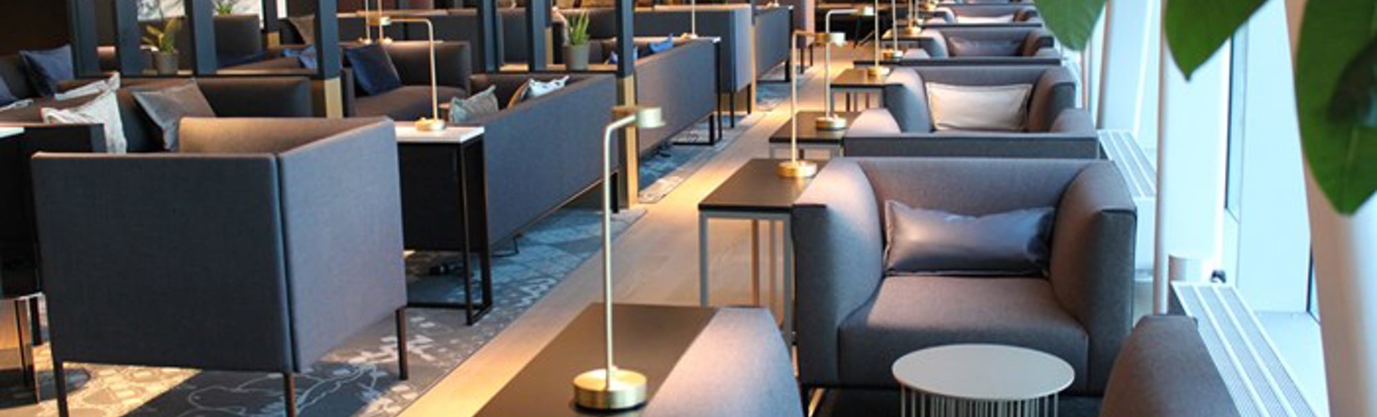Moderne flyplasslounge med elegante sitteplasser, stemningsfull belysning og moderne dekor, som skaper et komfortabelt og stilfullt miljø for reisende