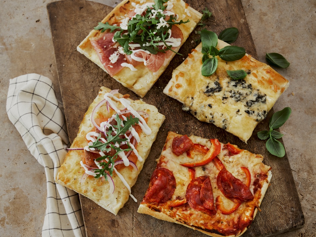 Fire forskjellige pizzastykke på trefjøl