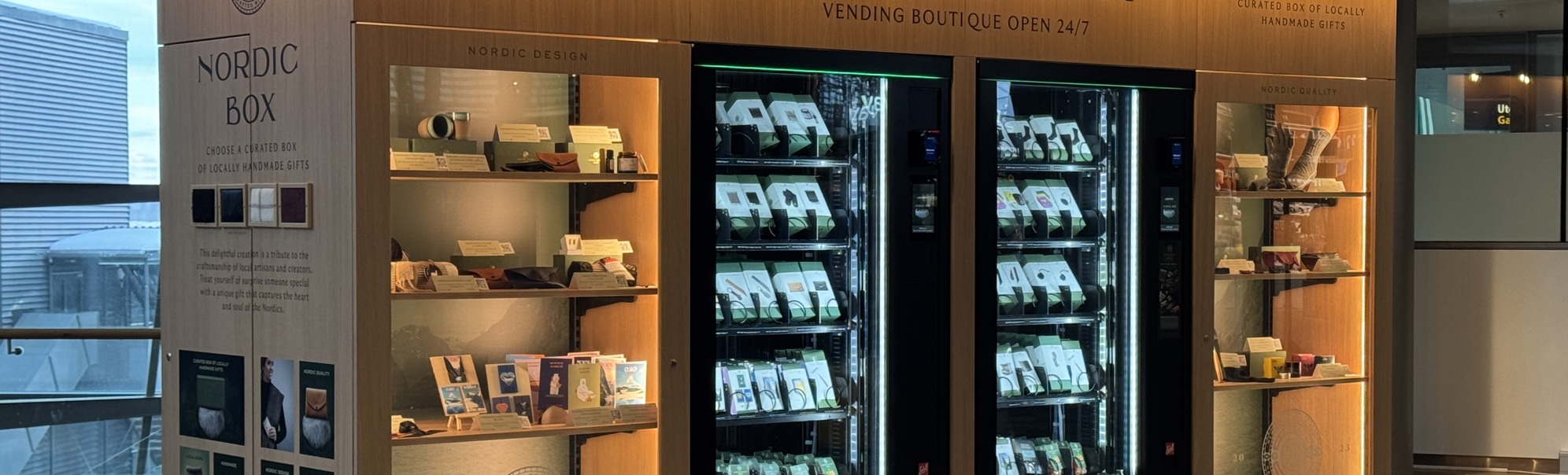 Automatisk butikk Nordic Box, tilgjengeleg 24/7, med handlaga lokale gåver på utstilling. Moderne design med utstillingshyller og automat i ein nordisk stil