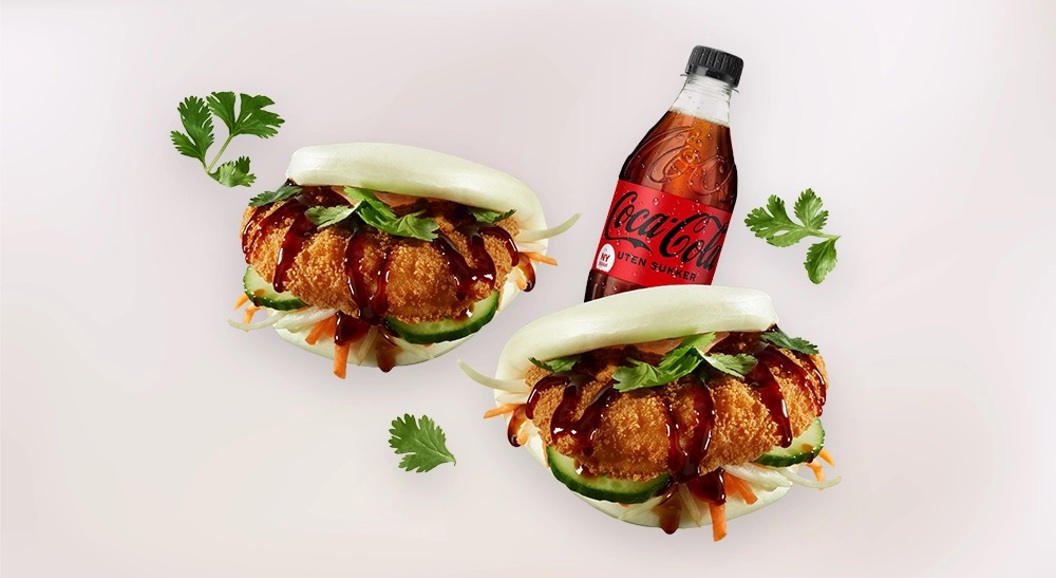 To bao-burgere med kylling, grønnsaker og koriandersaus, servert med en Coca-Cola uten sukker flaske