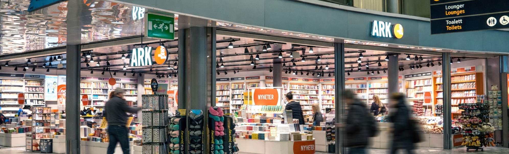 Kvinne ser på barnebøker i en bokhandel. Håndplukking av en bok fra hyllen i avdelingen for aldersgruppen 9-12 år.