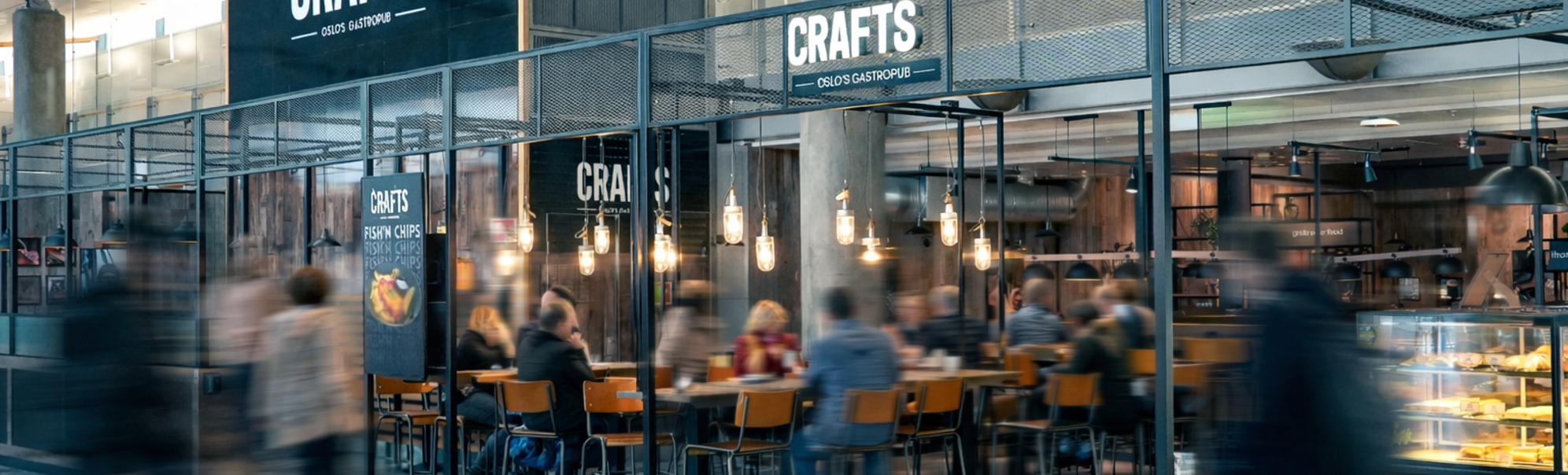 Interiør av CRAFTS gastropub på Oslo lufthavn med gjester, barområde og serveringsdisk