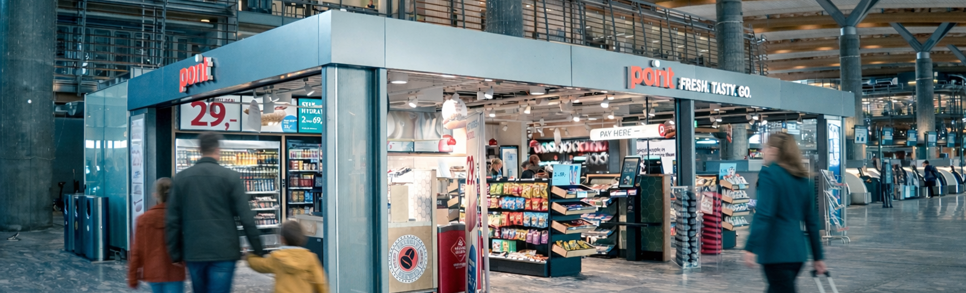 Kiosk i nærbutikk i en terminal på flyplassen med snacks, drikkevarer og magasiner utstilt