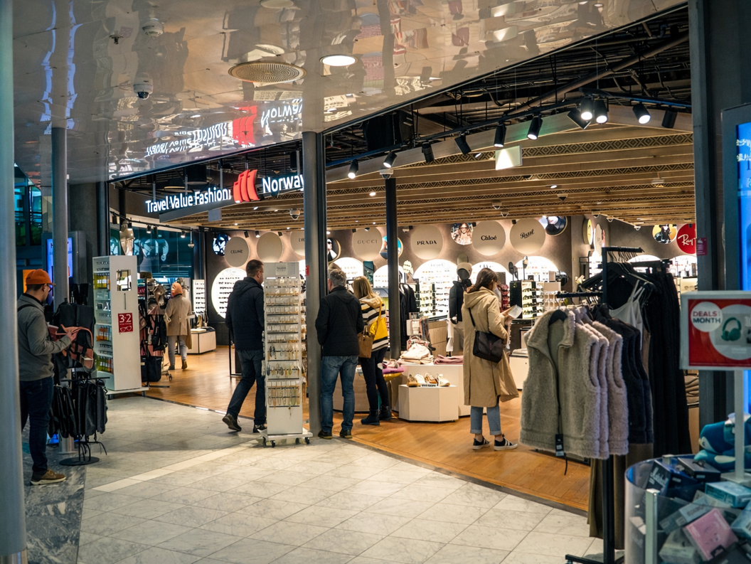 Person shopping for Persol sunglasses at an eyewear store display