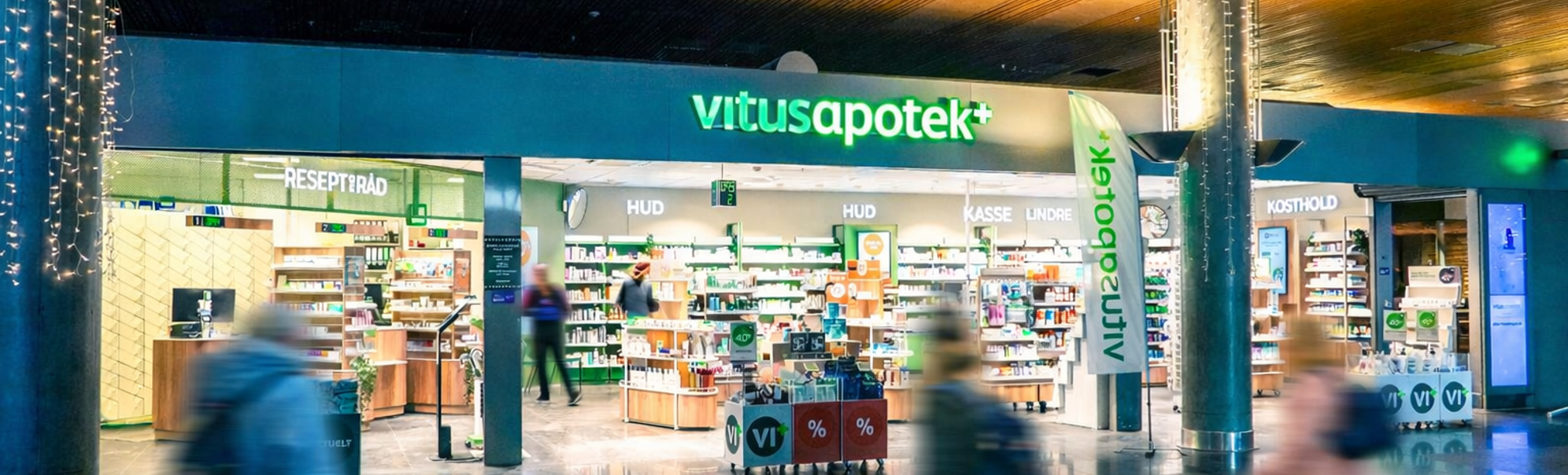 Vitusapotek skilt med grønne og hvite bokstaver, apoteksinngang
