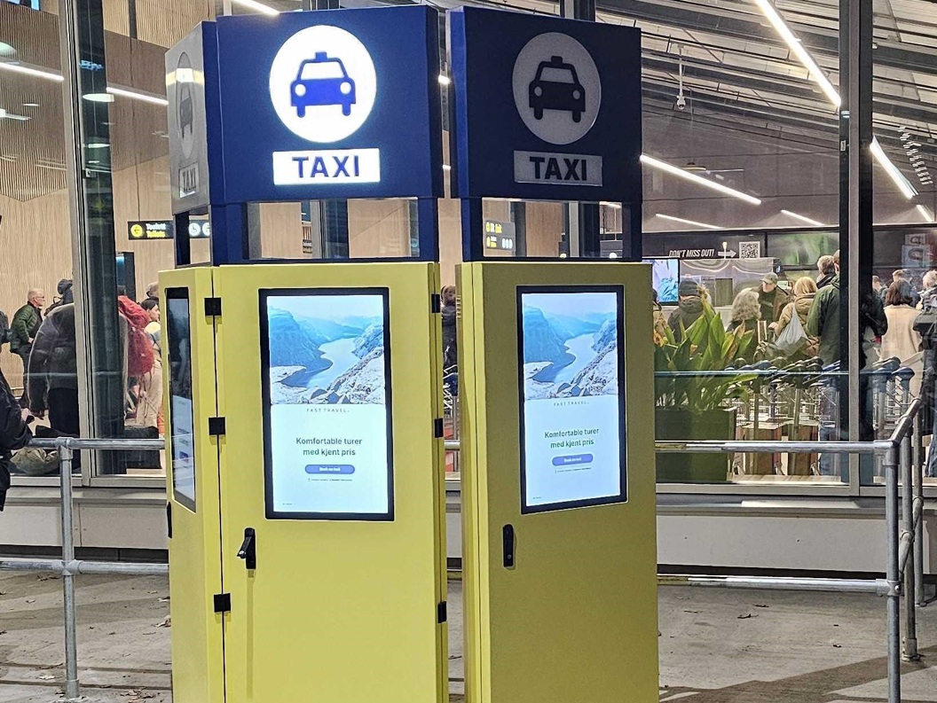 Interaktivt bestillingssystem for taxi i et terminalområde, med skjermer og taxisymboler